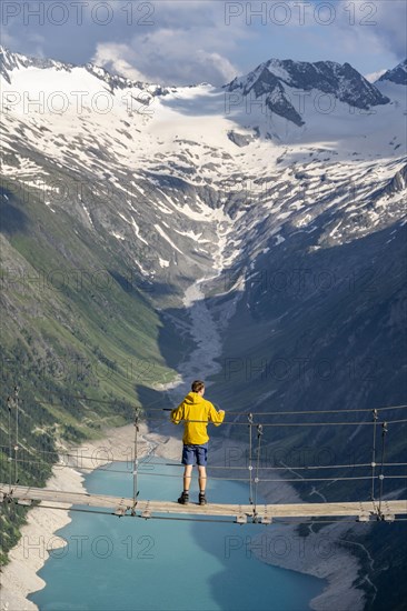 Mountaineers on a suspension bridge over a mountain stream Alelebach, picturesque mountain