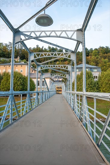 Pedestrian bridge with blue steel construction and clear sky in the background, Mozartsteg