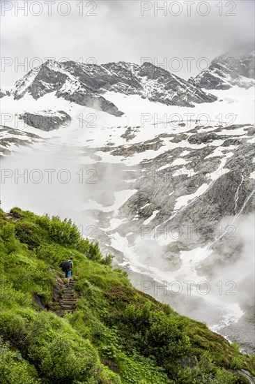 Mountaineers on a hiking trail, in the background glaciated peak Dosso Largo and glacier