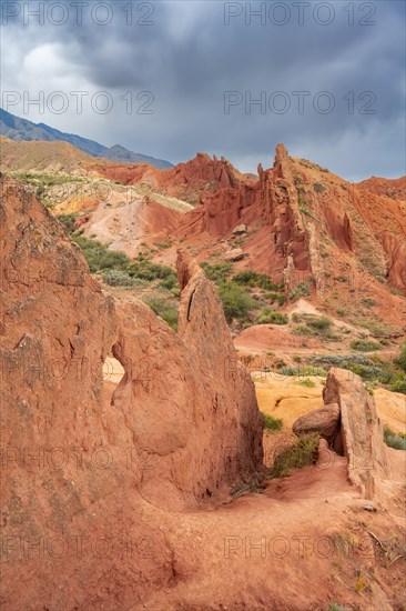 Eroded mountain landscape, sandstone cliffs, canyon with red and orange rock formations, Konorchek