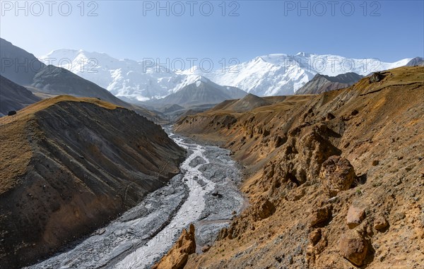 Achik Tash river, Achik Tash valley with rock formations, behind glaciated and snow-covered