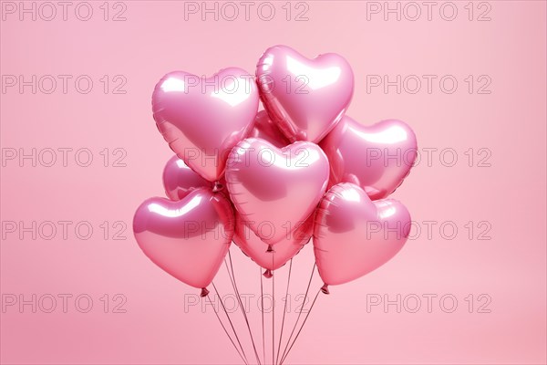 Bunch of glossy pink heart-shaped balloons against a soft pink background, perfect for Valentine