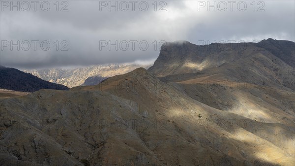 Low hanging clouds in the mountain landscape at the Tizi-n-Tichka pass road, High Atlas, Morocco,