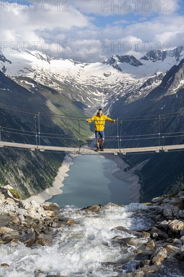 Mountaineers on a suspension bridge over a mountain stream Alelebach, picturesque mountain