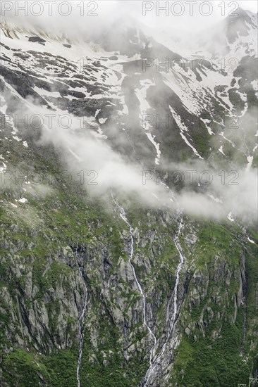 Snow-covered cloudy mountains, mountain streams as waterfalls on a mountain slope, Furtschaglhaus,