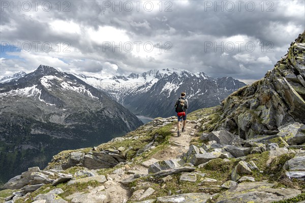 Mountaineer on hiking trail with snow, Berliner Hoehenweg, mountain landscape with glaciated peaks