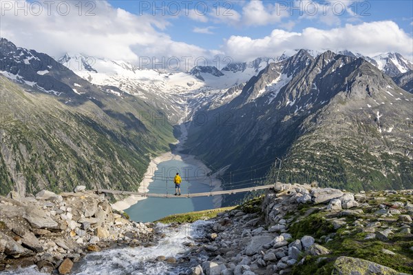 Mountaineers on a suspension bridge over a mountain stream Alelebach, picturesque mountain