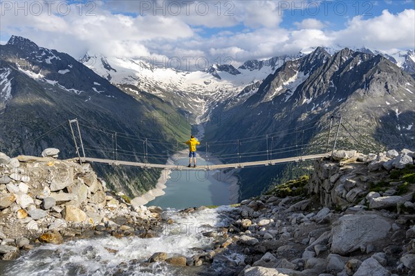 Mountaineers on a suspension bridge over a mountain stream Alelebach, picturesque mountain
