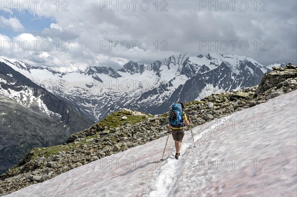 Mountaineer on hiking trail with snow, Berliner Hoehenweg, mountain landscape with glaciated peaks