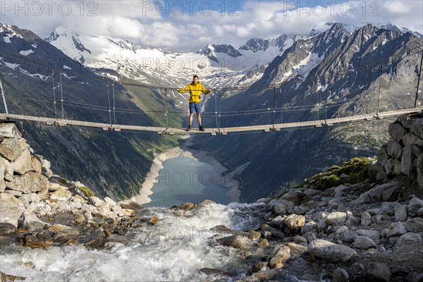 Mountaineers on a suspension bridge over a mountain stream Alelebach, picturesque mountain