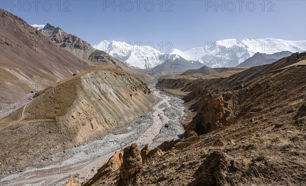 Achik Tash river, Achik Tash valley with rock formations, behind glaciated and snow-covered
