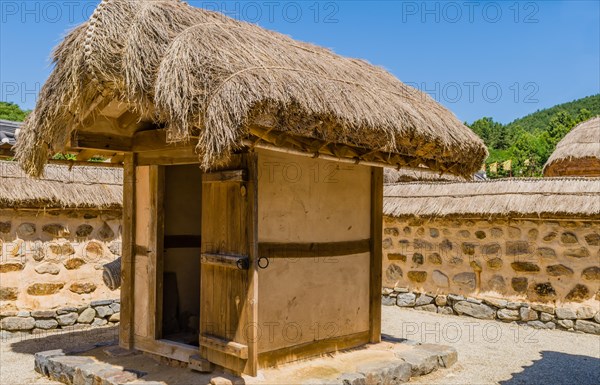 Buyeo, South Korea, July 7, 2018: Traditional outhouse with straw thatch roof and wooden door