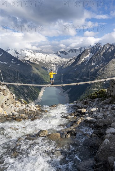 Mountaineers on a suspension bridge over a mountain stream Alelebach, picturesque mountain