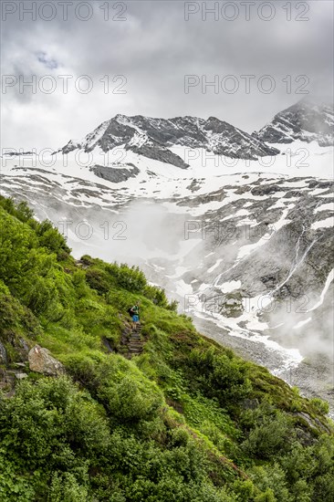 Mountaineers on a hiking trail, in the background glaciated peak Dosso Largo and glacier