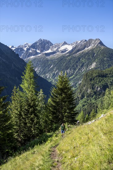 Mountaineers on a hiking trail, rocky mountain peaks Grosser Greiner and Kleiner Greiner with snow,