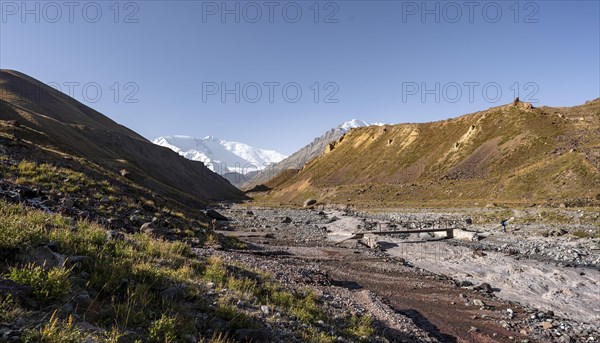 Bridge over the river Achik Tash, Achik Tash valley, behind glaciated and snow-covered mountain