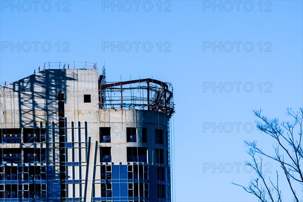 Yeoso, South Korea: December 25, 2017: Top of a building under construction with tree branches in