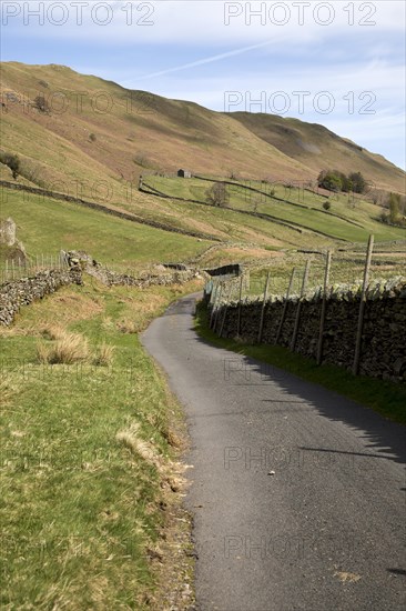Narrow road and dry stonewall, Boredale valley, Martindale, Lake District national park, Cumbria,