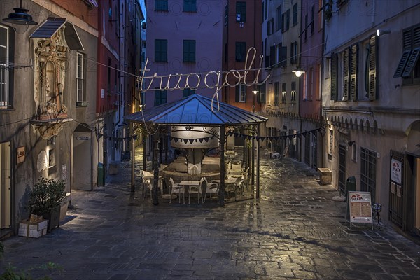 Rerstaurant seats in the evening in a historic public wash house, Piazza Truogoli di Santa Brigida,