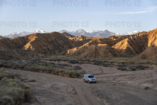 Off-road vehicle on off-road road, eroded hilly landscape, Badlands, Valley of the Forgotten