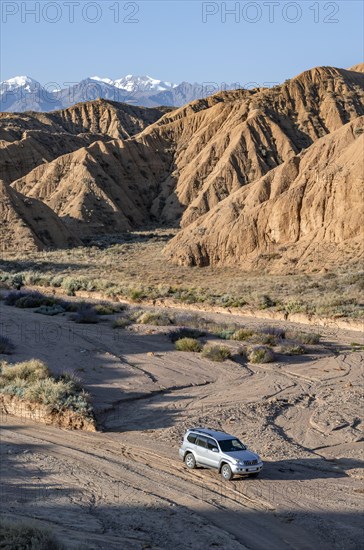 Off-road vehicle on off-road road, eroded hilly landscape, Badlands, Valley of the Forgotten