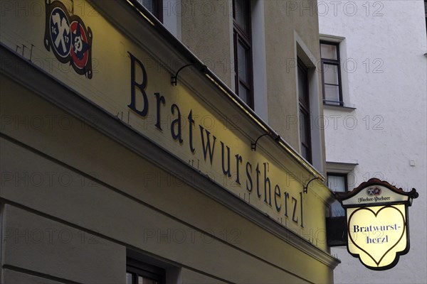Illuminated sign of the traditional restaurant Bratwurstherzl at Viktualienmarkt, Munich, Bavaria,