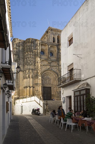 Narrow street cafe and church of Santa Maria de la Asuncion, Arcos de la Frontera, Cadiz province,