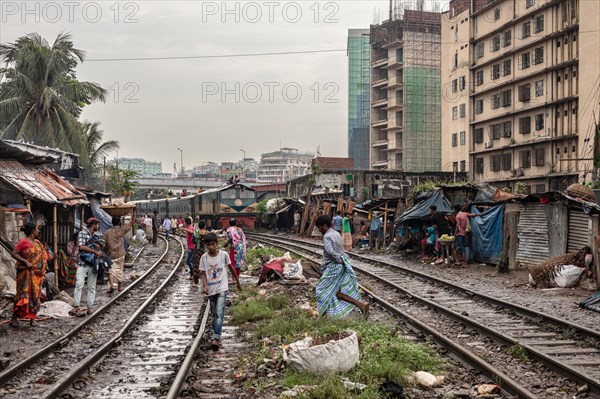 A train passes through an informal settlement built close to a railway line, Tejgaon Slum, Area,