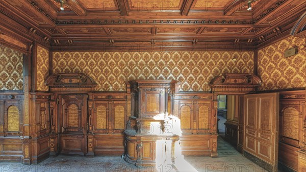 A sumptuously decorated room with wood panelling and antique furniture, Villa Woodstock, Lost