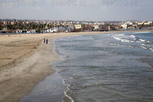 People walking on sandy beach Melilla autonomous city state Spanish territory in north Africa,
