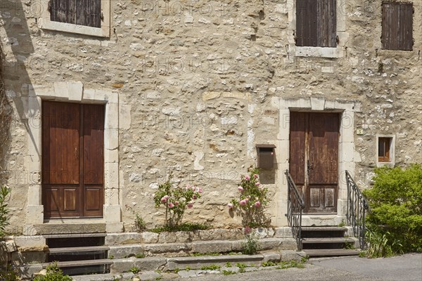 Facades of old houses with doors, windows and shutters in Goudargues, Departement Gard, Occitanie