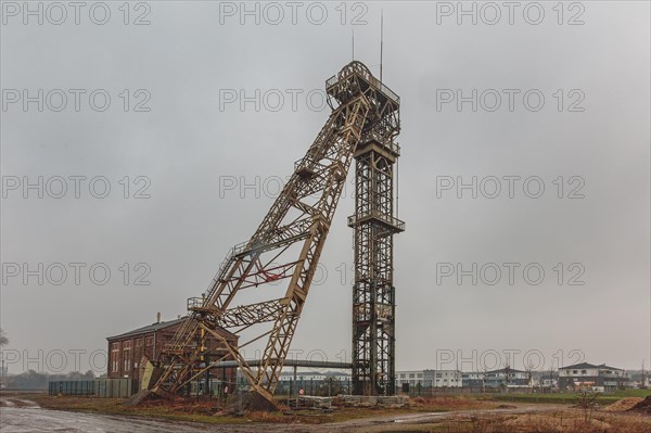 An old metal winding tower under a cloudy sky, a sign of the industrial past, Lost Place,