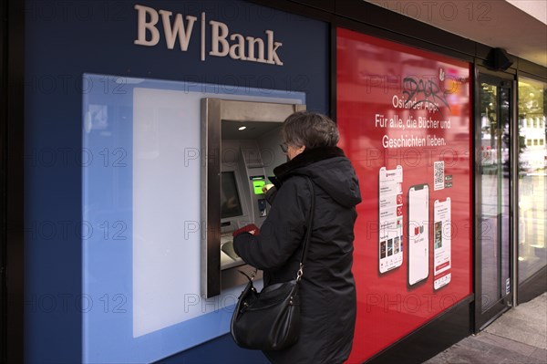 Elderly woman, best ager, inserts EC card, credit card, PIN, purse, ATM of BW-Bank