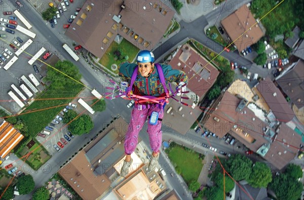 Paragliding pilot with colorful clothes, and small round sunglasses, flying high above Mayrhofen,