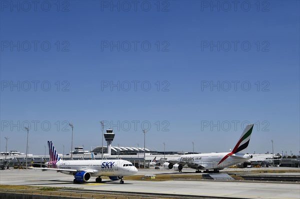 Sky Express Airbus A320 Neo and Emirates Airways Airbus A380-800 taxiing on apron in front of