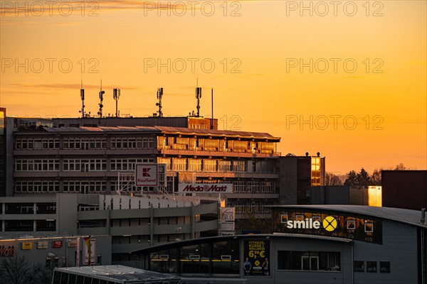 Building with antennas on the roof against a sky flooded with warm light at sunset, Wilferdinger