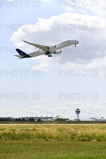 Lufthansa Airlines Airbus A350-900 taking off on Runway North with control tower, Munich Airport,