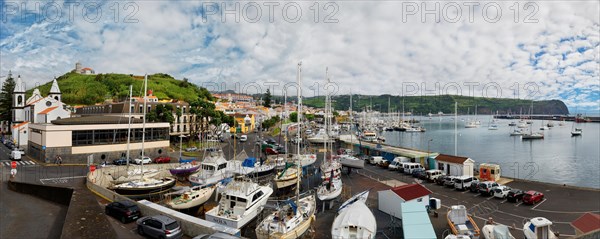 Wide angle shot of the harbour of Horta with boats, buildings and cars on the coastal road, Horta,