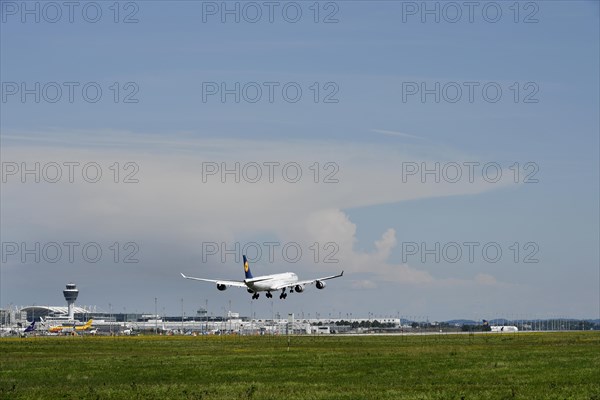 Lufthansa Airbus A340 landing on southern runway, with thundercloud and storm front in the
