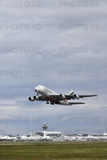 Emirates Airways Airbus A380-800 take-off on southern runway with control tower, Munich Airport,
