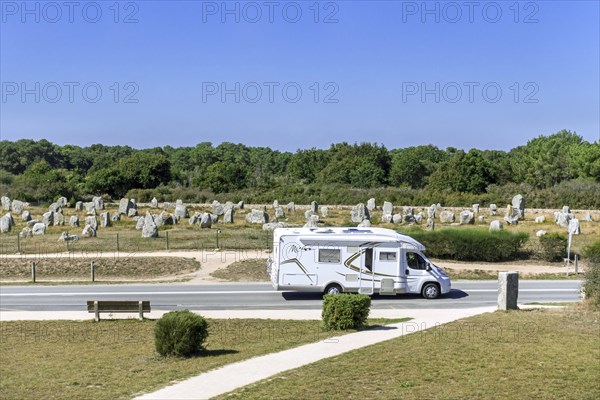 Motorhome, camper van driving past the Menec alignments, megalithic site among the Carnac standing