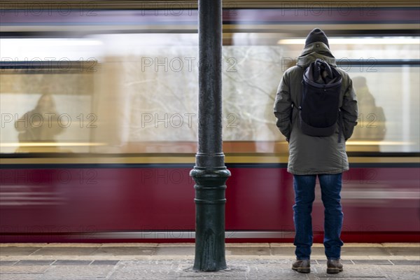 A man stands at Friedrichshagen S-Bahn station while the S-Bahn arrives. Today is the second day of