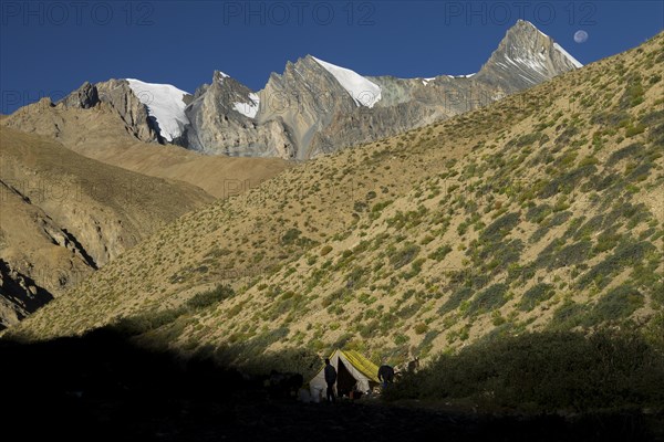 Moon setting above a trekker camp in the upper Kong Togpo Valley in Ladakh, with some high,