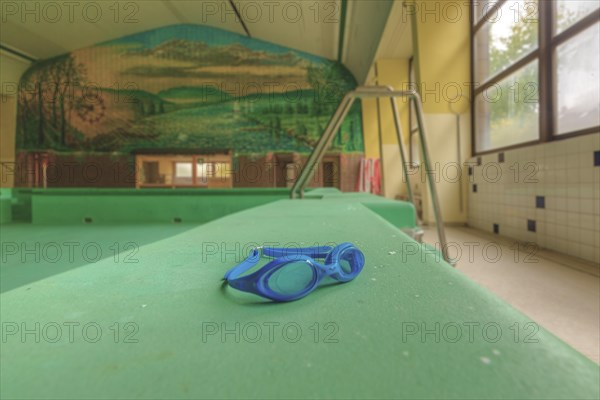 A lost diving diving goggles on a diving board in an empty swimming pool, Bad am Park, Lost Place,