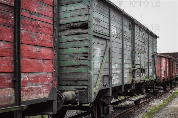A weathered red and green goods wagon stands on tracks in the railway museum, Dahlhausen railway