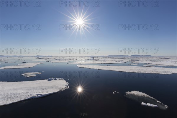 Midnight sun over the Arctic Ocean with drifting ice floes, north of the Arctic Circle at