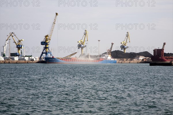 Cranes loading bulk carrier ship with rock ore at the port of Beni Ansar, Morocco, north Africa,
