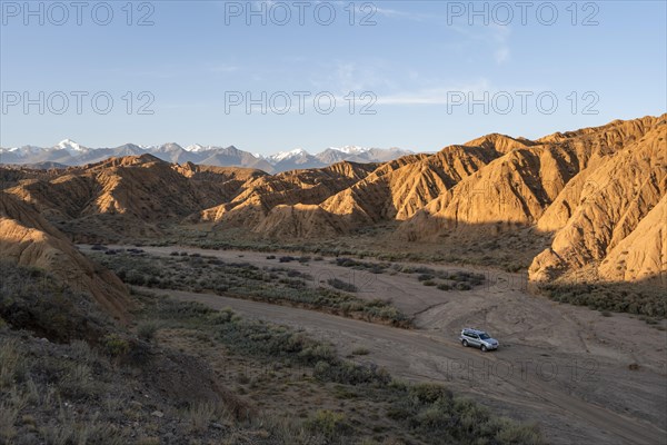 Off-road vehicle on off-road road, eroded hilly landscape, Badlands, Valley of the Forgotten