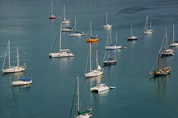 Several sailing boats on calm water with visible reflections, Monte da Guia, Horta, Faial Island,