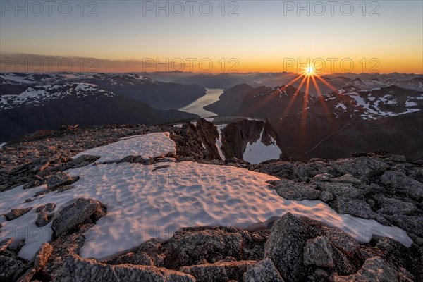 View of mountains and fjord Faleidfjorden, sun star at sunset, summit of Skala, Loen, Norway,